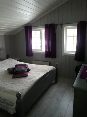 a bedroom with a bed and two windows at Haglebu Feriesenter in Eggedal