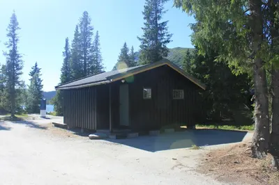 a small black building sitting on the side of a road at Haglebu Feriesenter in Eggedal