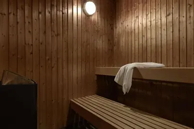 a sauna with a towel on a shelf and a tub at Scandic Hønefoss in Hønefoss