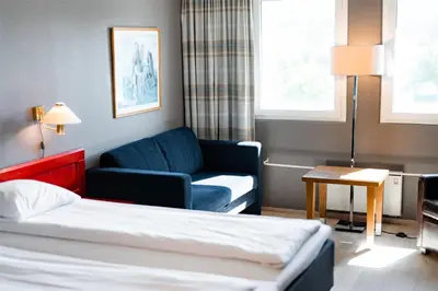 a hotel room with a bed and a couch at Scandic Hønefoss in Hønefoss