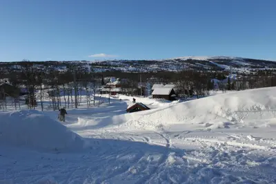 a person is skiing down a snow covered slope at Bergfosshytta in Ron