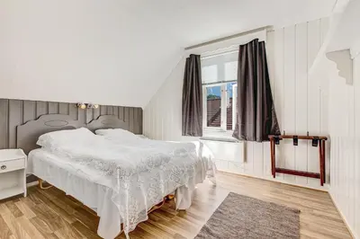 a bedroom with a white bed and a window at Vik Pensjonat in Eidfjord