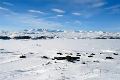 a snow covered field with houses and a mountain at Rødungstøl Høyfjellshotell in Rødungstøl