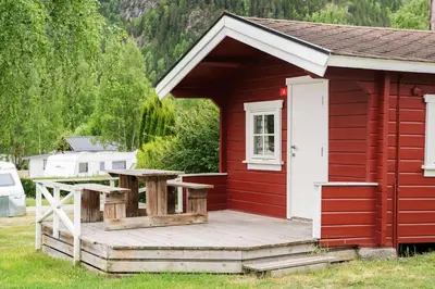 a red cabin with a picnic table on a deck at First Camp Gol Hallingdal in Gol