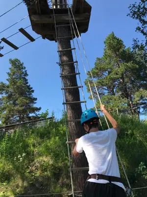 a boy in a helmet on a zip line at Geilo Superior leilighet in Geilo
