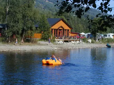 two people riding on an orange raft in the water at Camp Uvdal in Uvdal