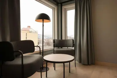 a living room with chairs and a table and a window at Scandic Victoria Lillehammer in Lillehammer