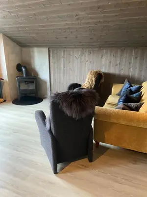 a person laying on a couch in a living room at Jotunheimen Husky Lodge in Randsverk