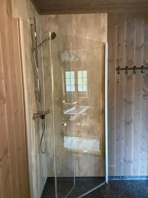 a shower with a glass door in a bathroom at Jotunheimen Husky Lodge in Randsverk