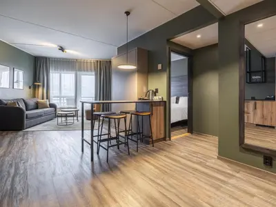 a kitchen and living room with a bar and a couch at Radisson Blu Resort, Trysil in Trysil