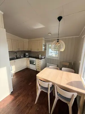 a kitchen with a large wooden table and chairs at Sveastranda Camping in Gullor