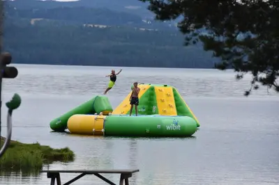 two people are riding on an inflatable raft in a lake at Sveastranda Camping in Gullor