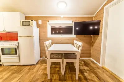a small kitchen with a white table and chairs at Sveastranda Camping in Gullor