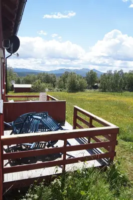 a wooden fence in front of a field with a view at Bustad Hyttetun in Skåbu