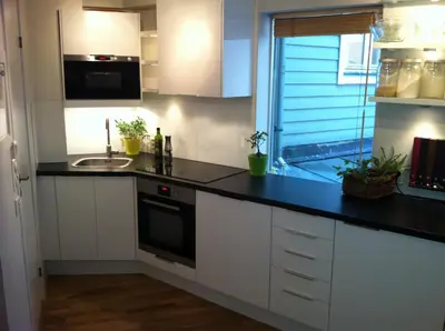 a kitchen with white cabinets and a black counter top at Central location in the heart of historic Bergen in Bergen
