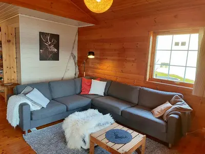 a living room with a couch and a table at Cosy chalet, 100m2 with fjordview! in Lauvstad