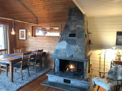 a fireplace in a dining room with a table and chairs at Cosy chalet, 100m2 with fjordview! in Lauvstad