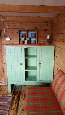 a green cabinet in a room with a couch at Tiny house with Fjordview! in Lauvstad