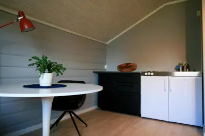 a kitchen with a white table and a white refrigerator at Bøflaten Camping AS in Vang I Valdres