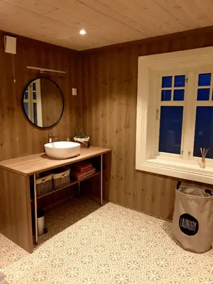 a bathroom with a sink and a mirror and a window at Fjords view in Sjøholt