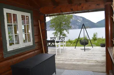 a porch of a cabin with a view of the water at Sunndalsfjord Cottages Fredsvik Meisalstranda 455,506 og 508 in Sunndalsøra