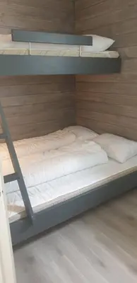 a bunk bed with white sheets and a ladder at Oppdal Alpintun Stølen ski in - ski out in Oppdal