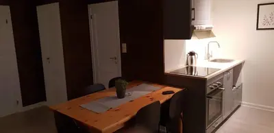 a small kitchen with a wooden table and a sink at Oppdal Alpintun Stølen ski in - ski out in Oppdal
