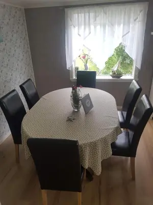 a dining room table with chairs and a window at Lille Villa Severin in Mosterhamn