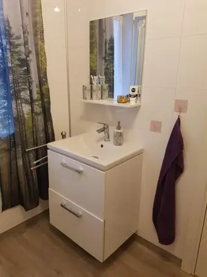 a white bathroom with a sink and a mirror at Lille Villa Severin in Mosterhamn