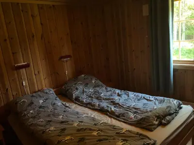 a bed in a room with a comforter on it at Sjoaasen Hytte in Tuddal