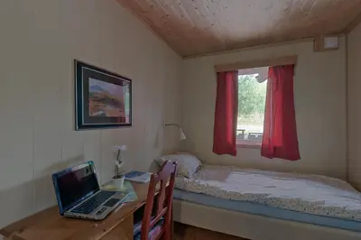 a bedroom with a bed and a laptop on a desk at Trysil Motell & Vandrerhjem in Trysil