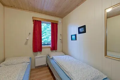 two beds in a small room with a window at Trysil Motell & Vandrerhjem in Trysil