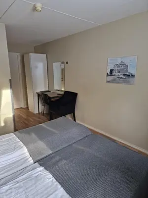 a bedroom with a bed and a table in it at Badeland Gjestegård in Raufoss