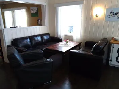 a living room with a leather couch and a table at Badeland Gjestegård in Raufoss