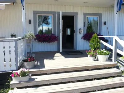a porch of a house with potted plants and flowers at Badeland Gjestegård in Raufoss