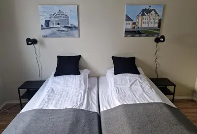 two beds sitting next to each other in a room at Badeland Gjestegård in Raufoss