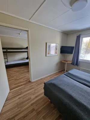a bedroom with a bed and a desk and a window at Badeland Gjestegård in Raufoss