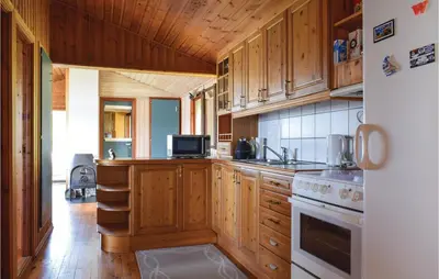 a kitchen with wooden cabinets and a stove top oven at Lovely Home In Sandvoll With Wifi in Sandvoll