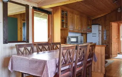 a dining room with a table and chairs in a cabin at Lovely Home In Sandvoll With Wifi in Sandvoll