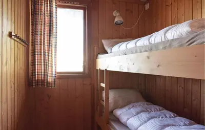 two bunk beds in a cabin with a window at Lovely Home In Sandvoll With Wifi in Sandvoll