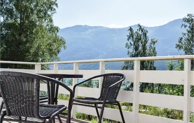 two chairs and a table on a balcony with mountains at 3 Bedroom Lovely Home In Vallavik in Vangsbygd