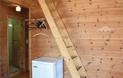 a stair in a log cabin with a refrigerator at 3 Bedroom Lovely Home In Vallavik in Vangsbygd