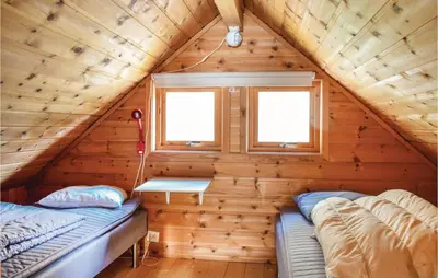 a bedroom in a log cabin with two beds at 3 Bedroom Lovely Home In Vallavik in Vangsbygd