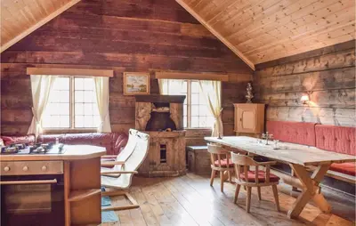 a kitchen with a table and a stove in a cabin at 1 Bedroom Cozy Home In Vallavik in Kaland