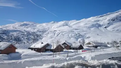 a snow covered mountain with a group of houses at Røldal in Røldal