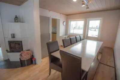 a dining room with a table and chairs and a fireplace at Fjelltun 12-Sengs in Trysil