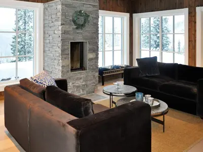 a living room with leather furniture and a stone fireplace at 12 person holiday home in Fåvang in Favang