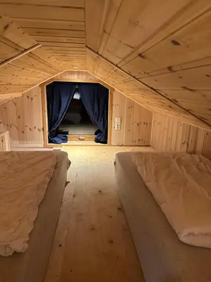 a small bedroom with two beds in a room at Haugo Utleige Lodge in Vossevangen