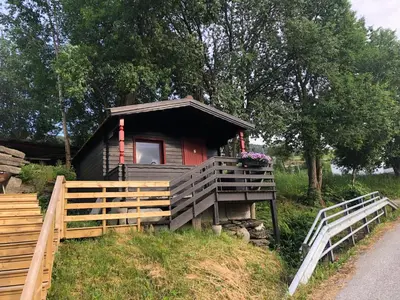 a small cabin with a fence in front of it at Haugo Utleige Lodge in Vossevangen