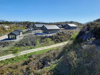 a row of houses on a hill with a dirt road at Atlanterhavsveien Rorbuer in Averoy